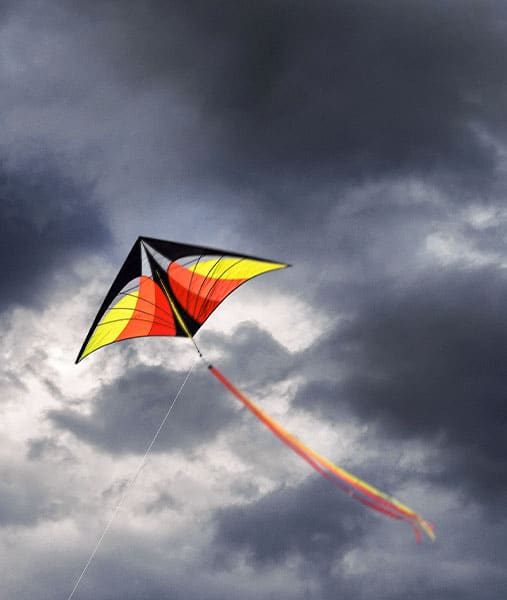 Ein gelb-roter Drache vor dunkelgrauen Wolken als Zeichen von Stärke und Resilienz in schwierigen Zeiten